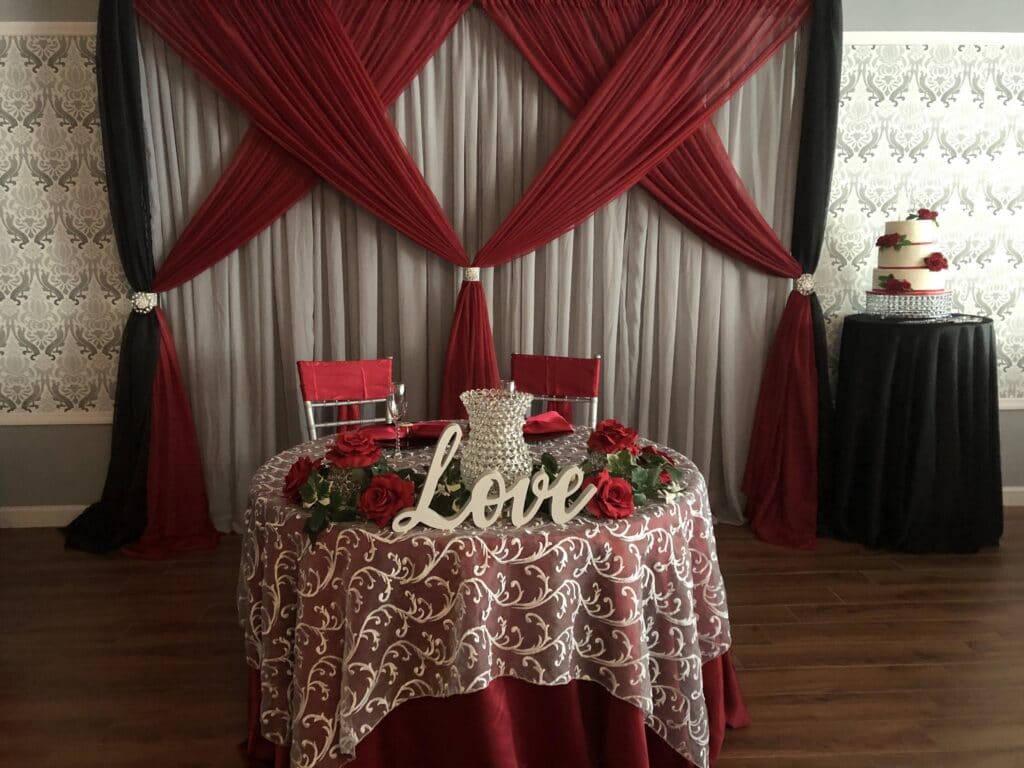 small table with Love sign on red and white tablecloth and two chairs